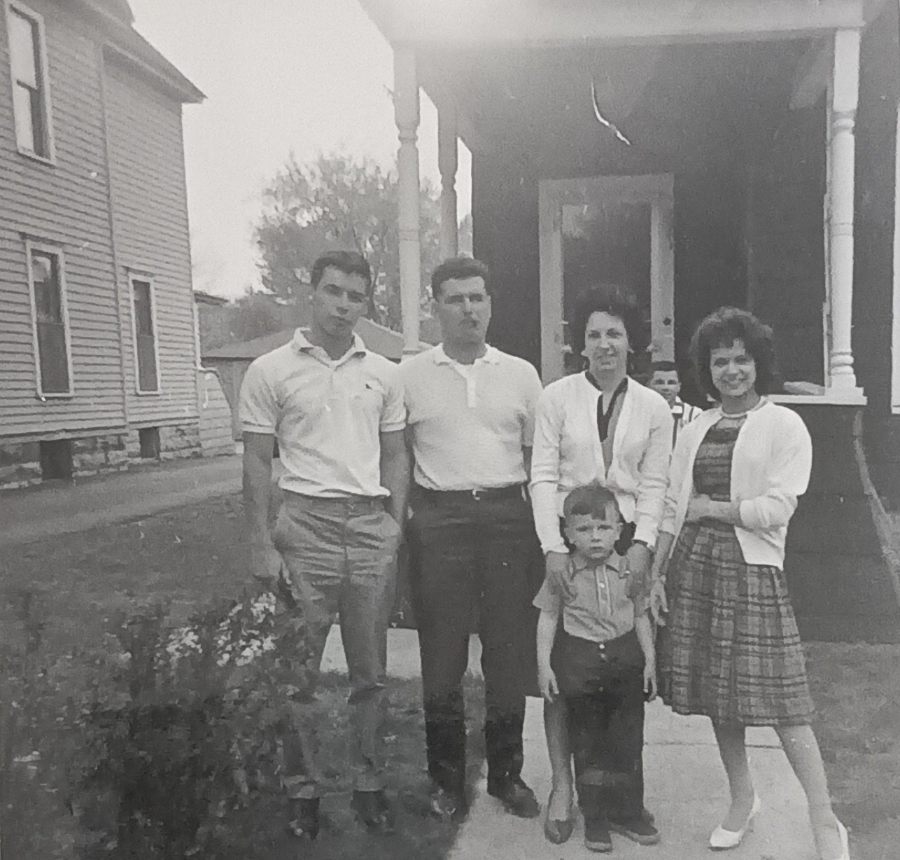 A group of people standing outside a house

Description automatically generated