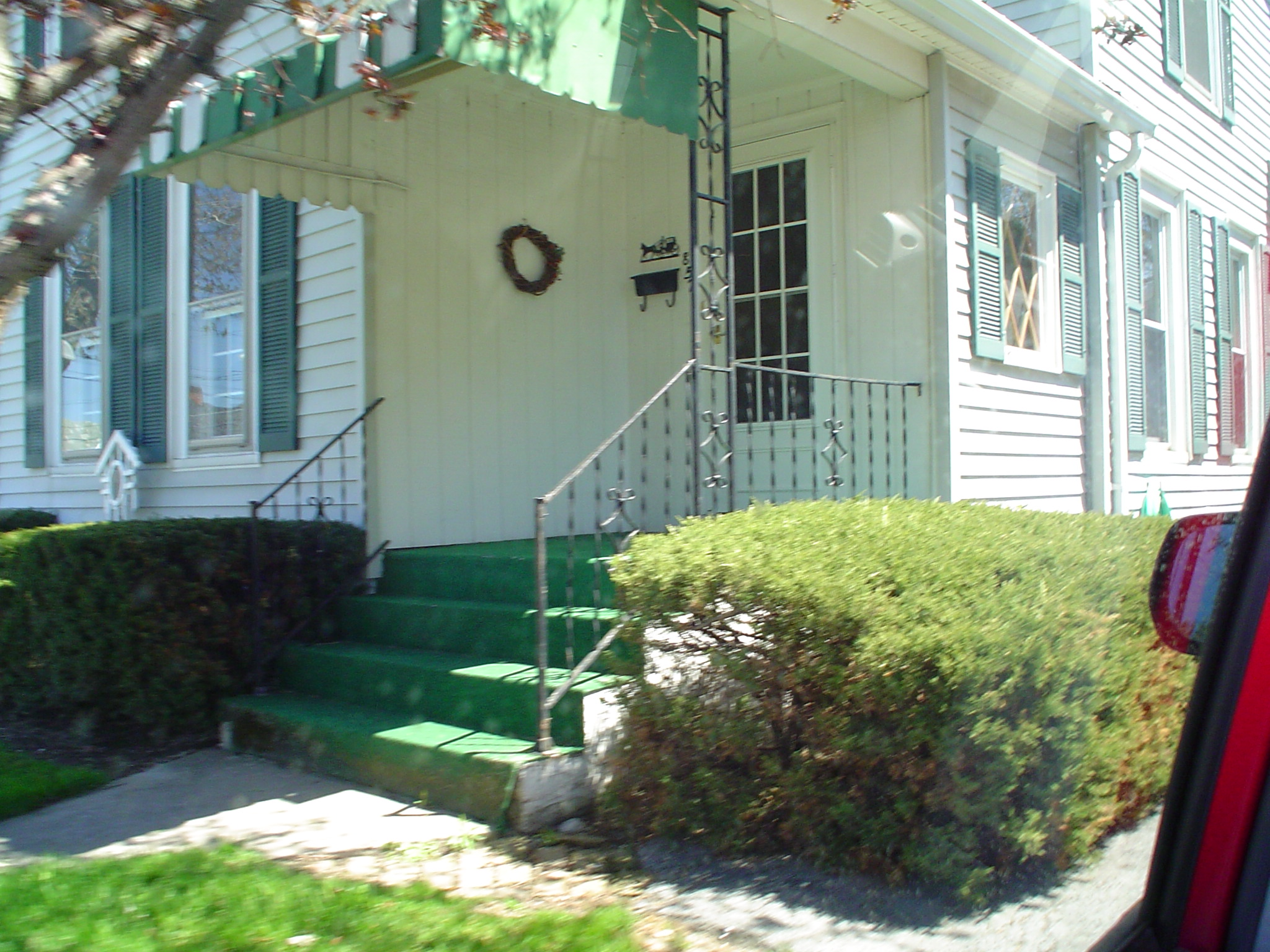 A house with green steps and a green awning

Description automatically generated